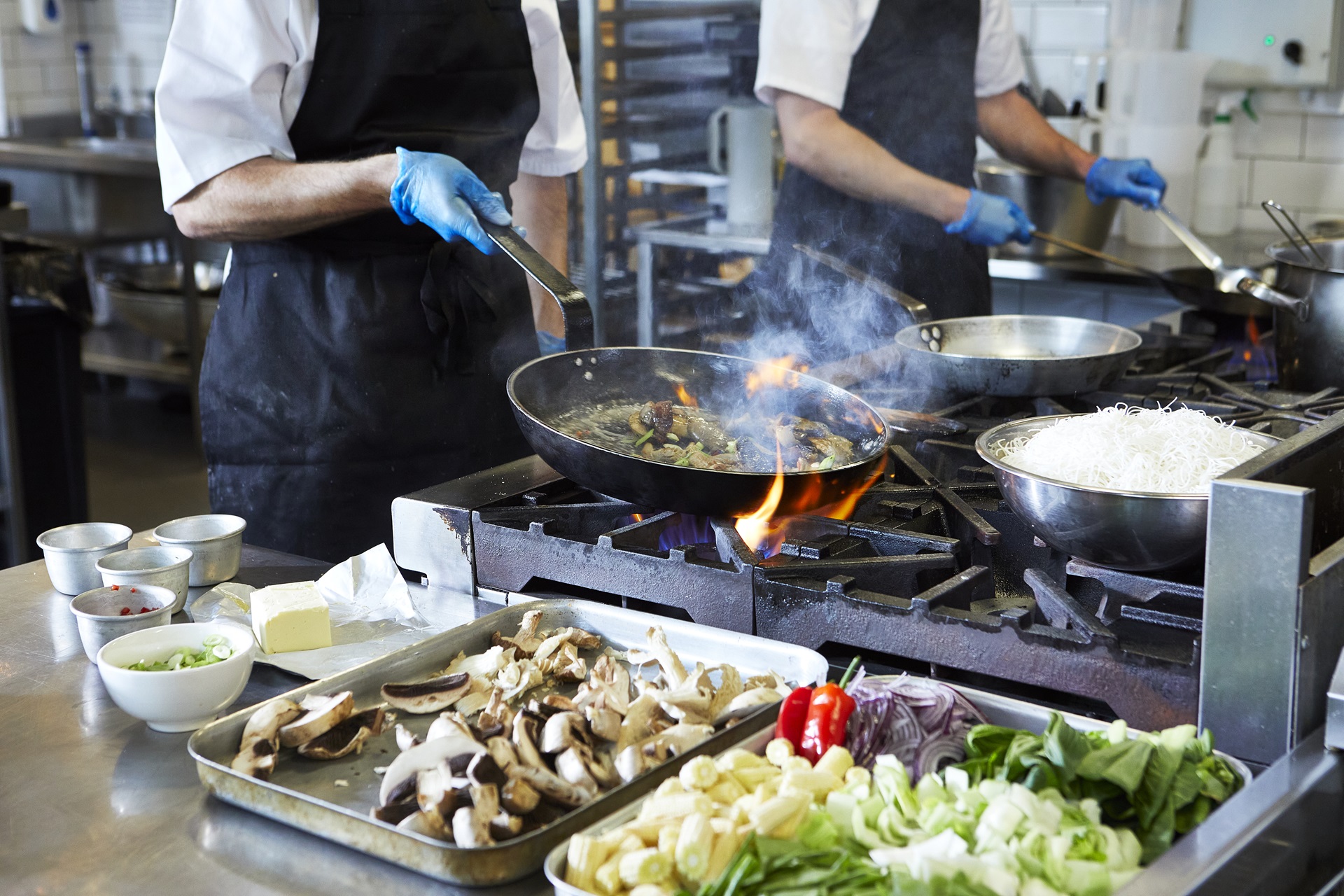 Chef salteando vegetales en un wok con margarina Phase vegana y sin alérgenos.