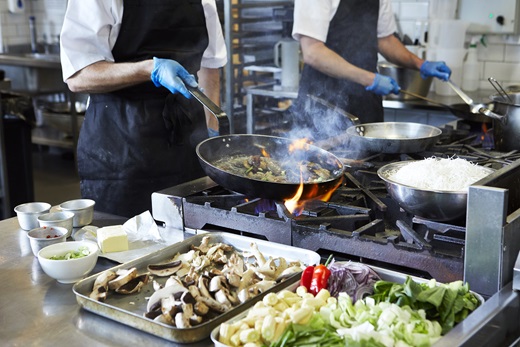 Chef salteando vegetales en un wok con margarina Phase vegana y sin alérgenos.